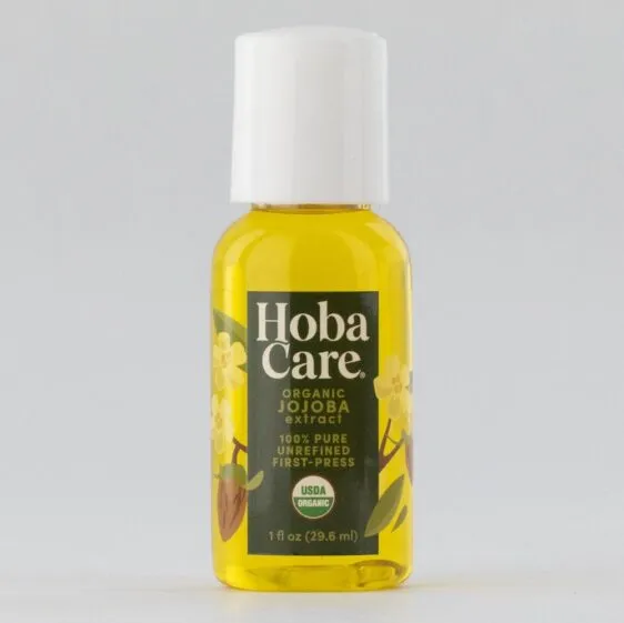 1 ounce clear bottle filled with golden organic jojoba on a gray background