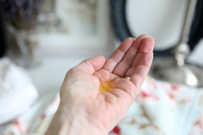 golden jojoba oil in palm in preparation for oil cleansing