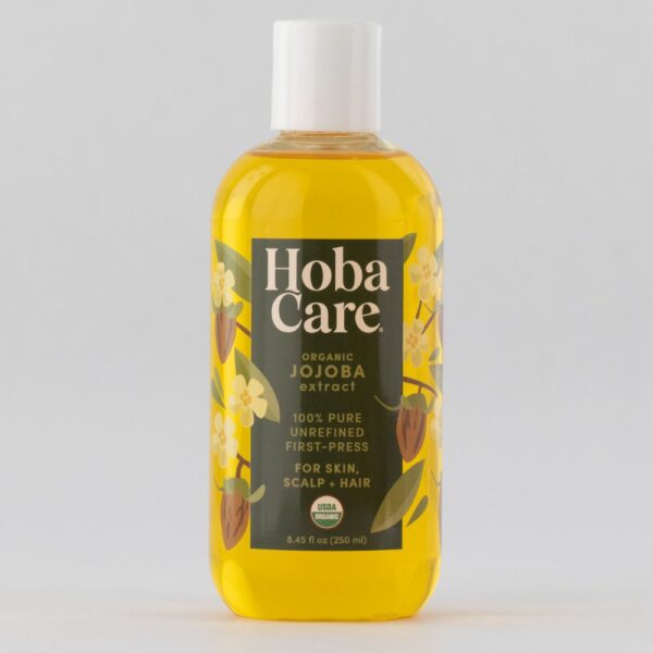 clear plastic bottle filled with golden HobaCare Organic jojoba on gray background