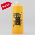 32 fl oz bottle of golden HobaCare Jojoba on light gray background